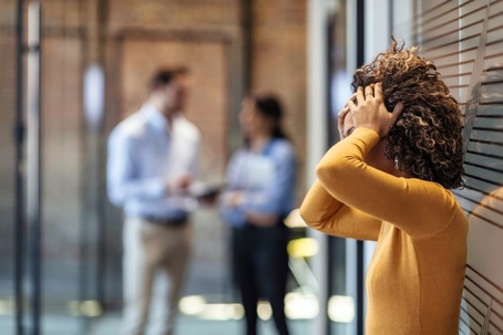 A women at work with her head in her hands upset